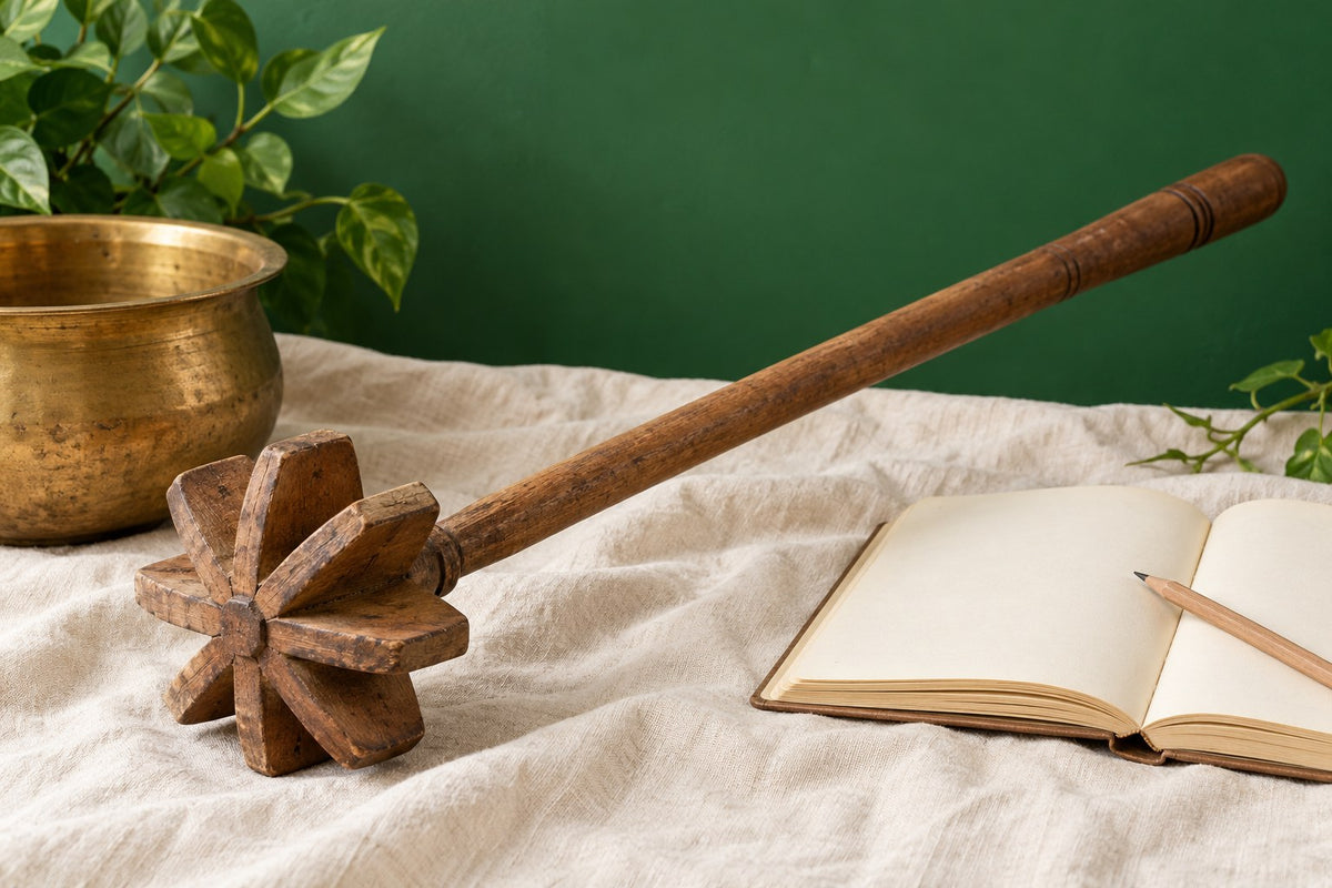 AI-generated illustration of a wooden mathani beside a brass vessel, blank notebook and pencil on ivory linen.